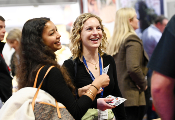 two women laughing at a conference