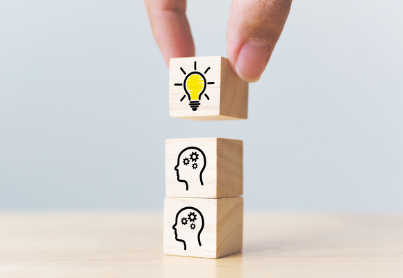 stacking blocks with images, two images of heads with cogs, one of a lightbulb